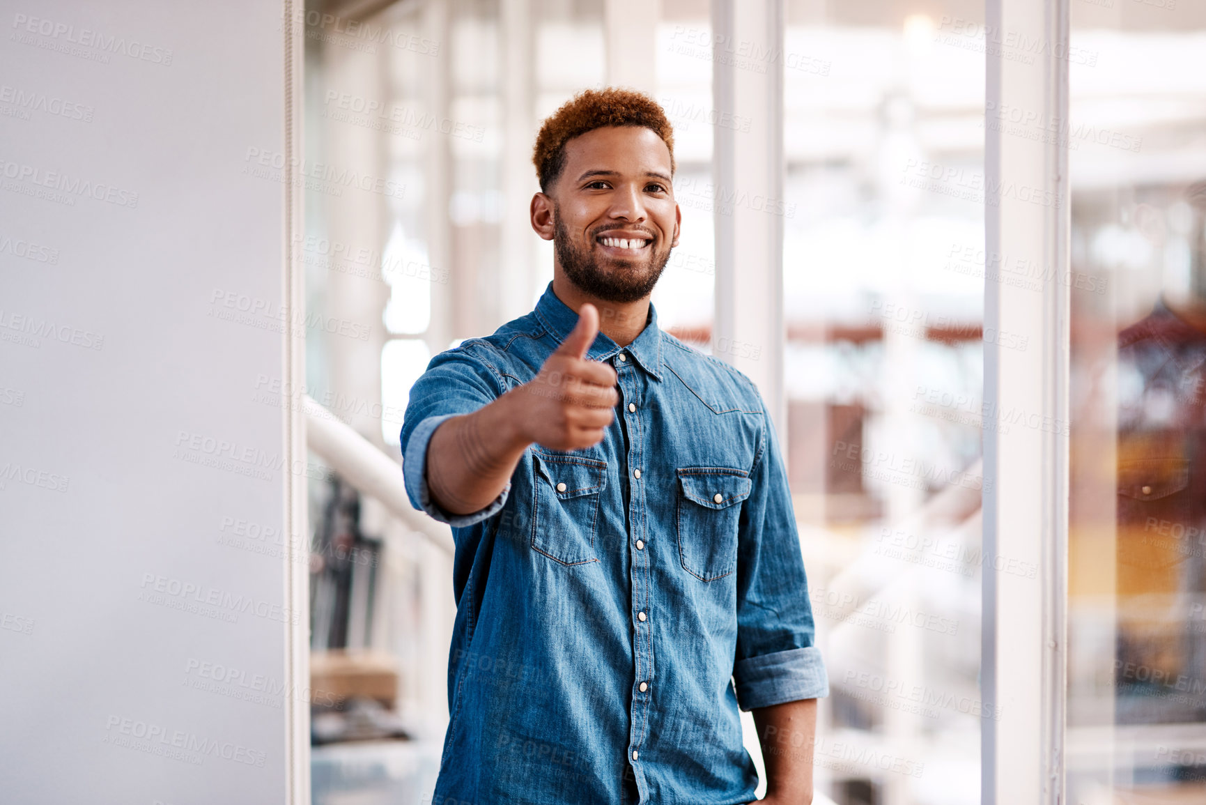 Buy stock photo Cropped portrait of a handsome young male designer giving thumbs up to the camera while standing in his office