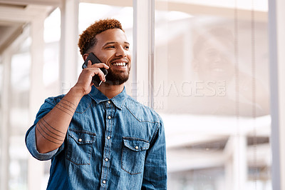 Buy stock photo Cropped shot of a handsome young male designer making a phonecall while standing at at a window in his office