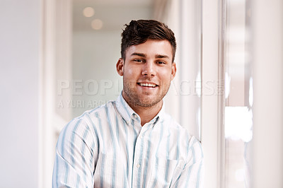 Buy stock photo Cropped portrait of a handsome young male designer standing with his arms folded in the office