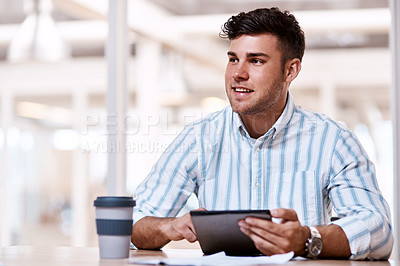 Buy stock photo Cropped shot of a handsome young male designer using his tablet while sitting in the office