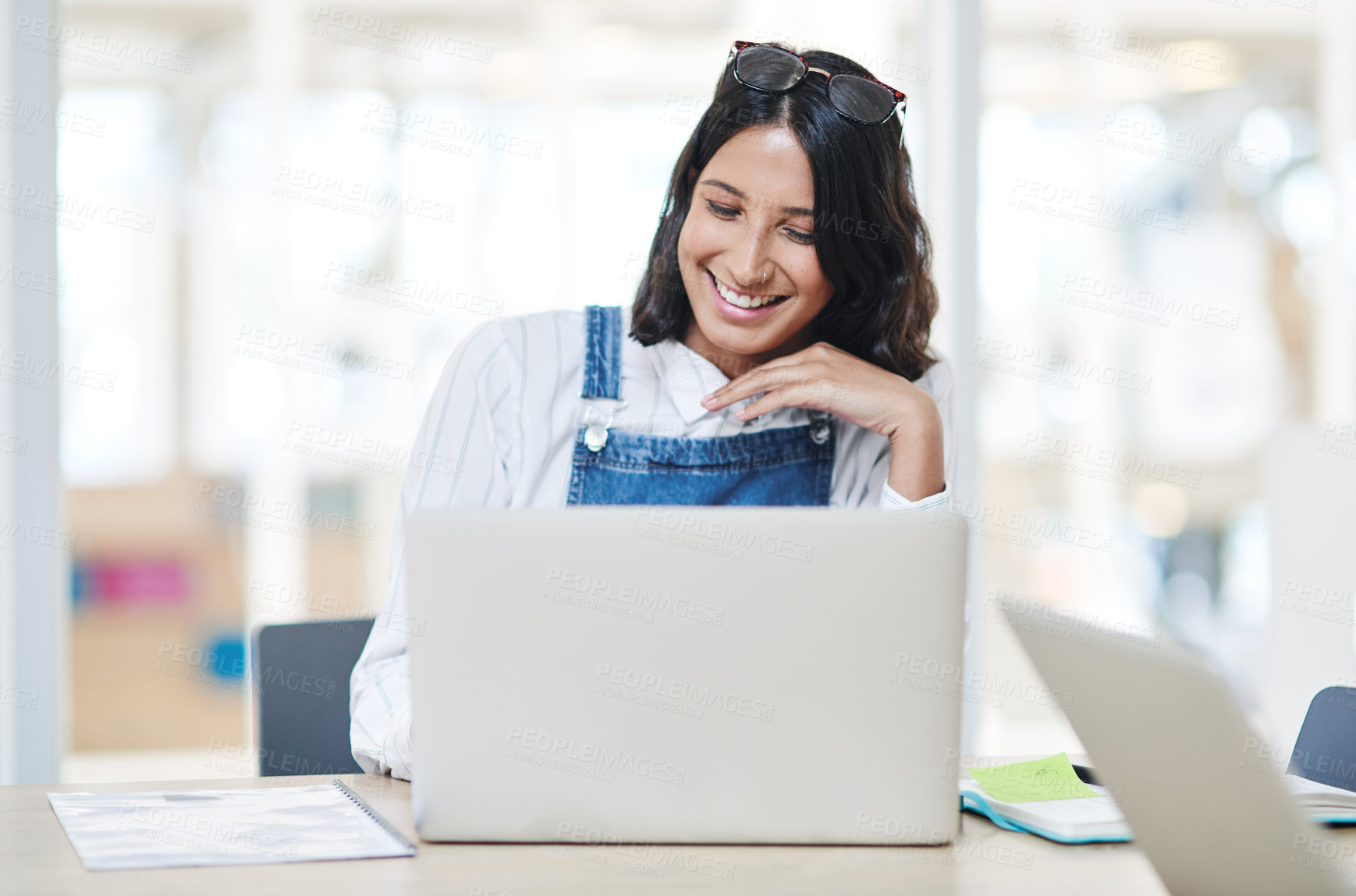 Buy stock photo Shot of a young businesswoman using a laptop in an office