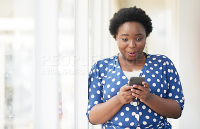 Buy stock photo Shot of a young businesswoman looking surprised while using a cellphone in an office