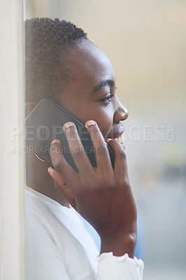 Buy stock photo Shot of a young businesswoman talking on a cellphone in an office