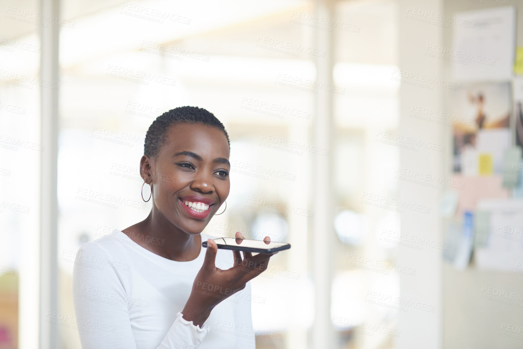 Buy stock photo Shot of a young businesswoman using a cellphone in an office