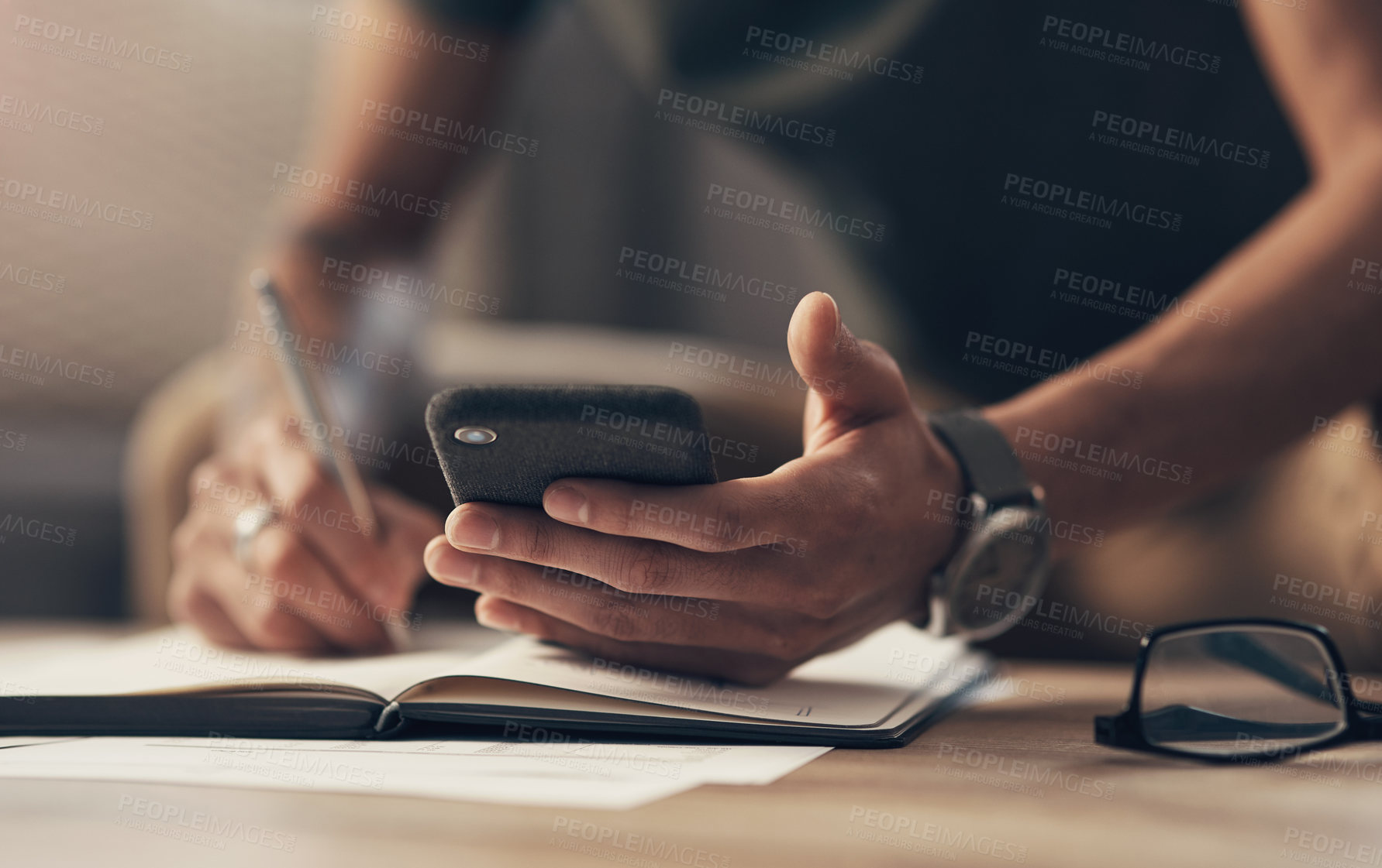 Buy stock photo Phone, hands and student writing notes on book for learning, remote education or research. Mobile, pen and closeup of man with notebook for knowledge, study app and test preparation on table in home