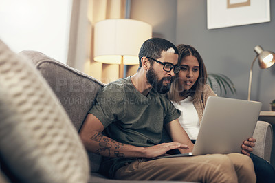 Buy stock photo Shot of a young couple using a laptop on the sofa at home