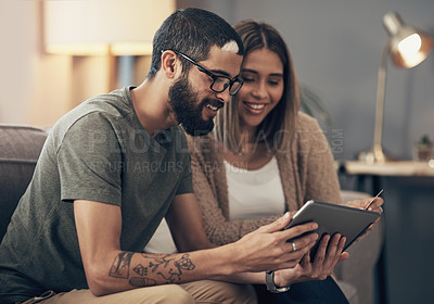 Buy stock photo Shot of a young couple using a digital tablet and credit card on the sofa at home