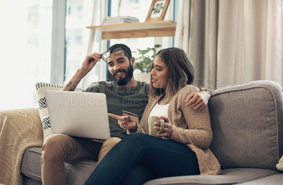 Buy stock photo Shot of a young couple using a laptop and credit card on the sofa at home