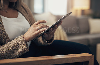Buy stock photo Cropped shot of a woman using a digital tablet on the sofa at home