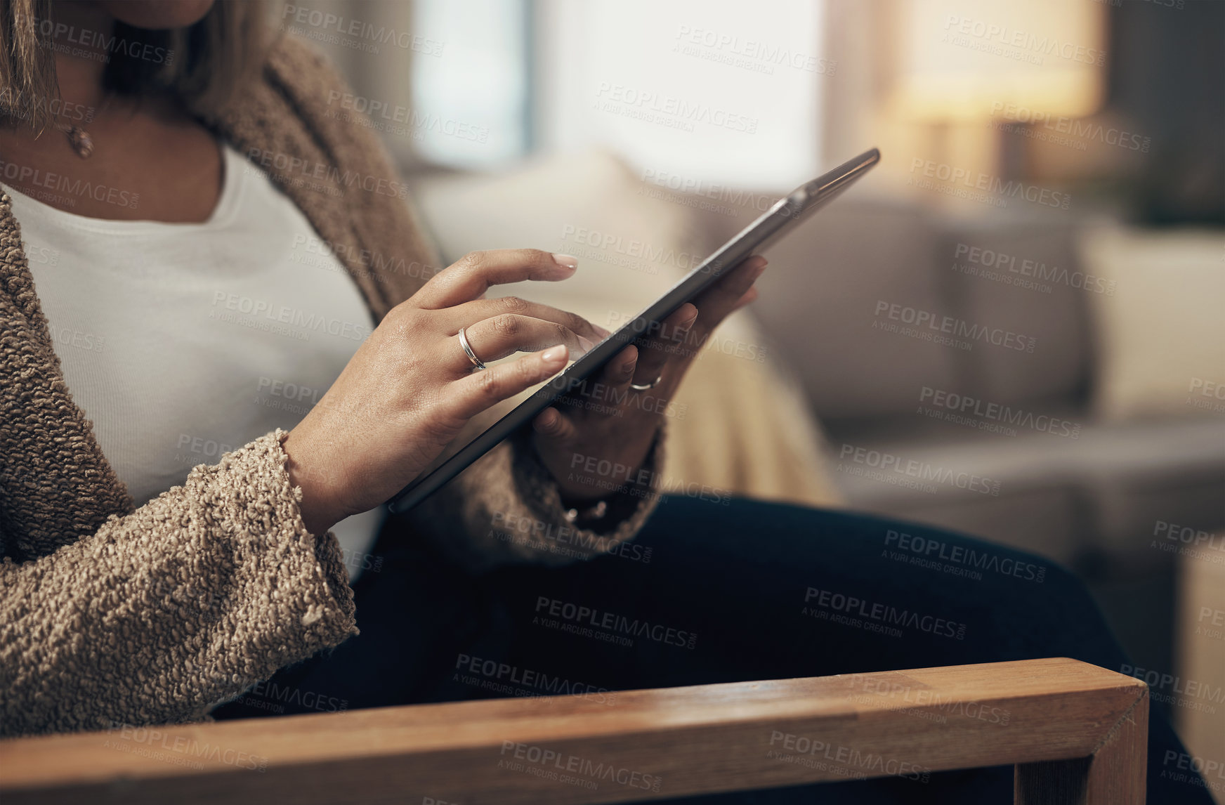 Buy stock photo Cropped shot of a woman using a digital tablet on the sofa at home