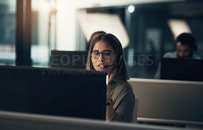 Buy stock photo Shot of a call centre agent working in an office at night