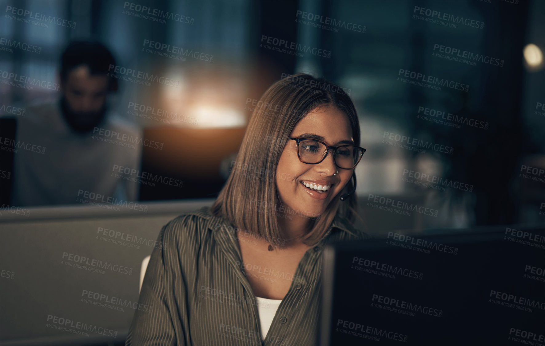 Buy stock photo Shot of a call centre agent working in an office at night