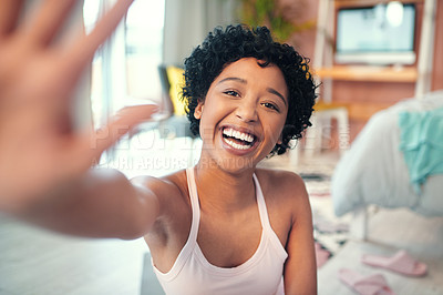 Buy stock photo Portrait shot of a young woman waving while recording herself at home