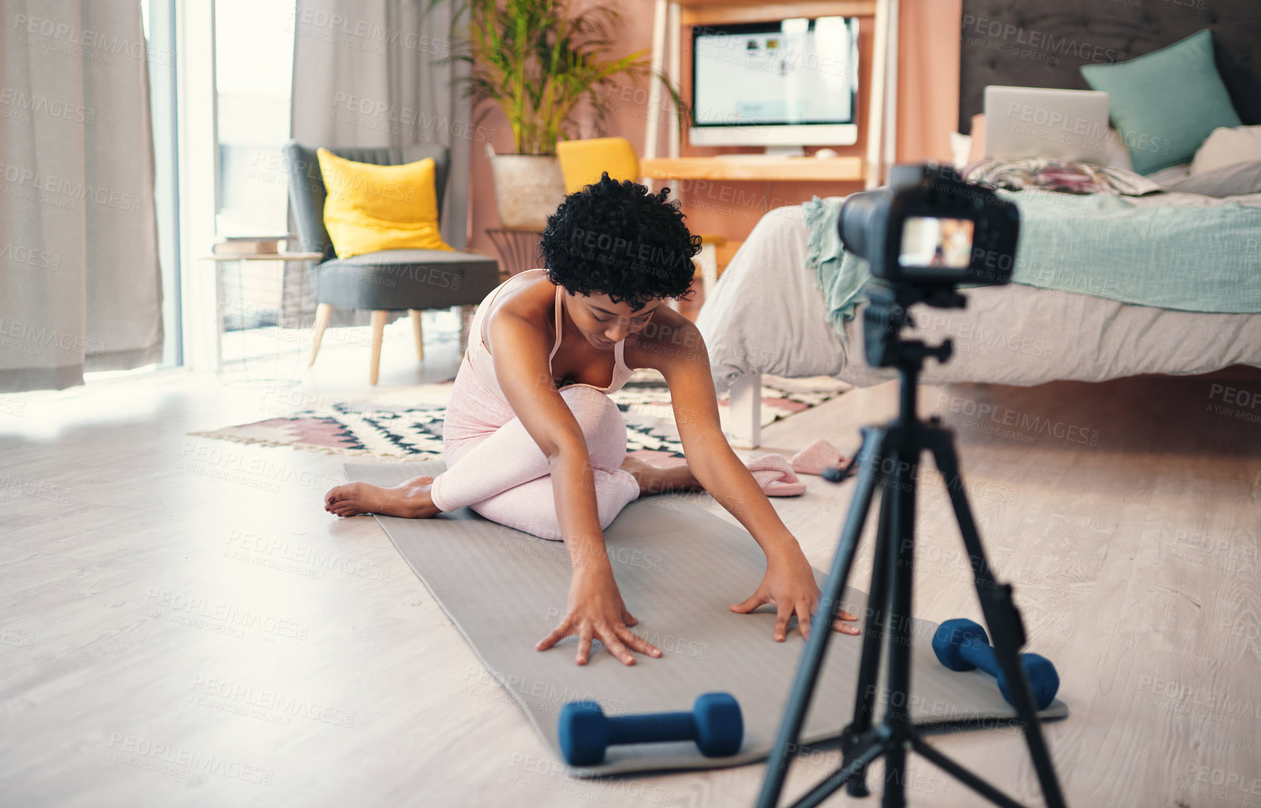 Buy stock photo Shot of a young woman recording herself while exercising at home