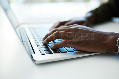 Buy stock photo Cropped shot of an unrecognisable businessman using a laptop at his desk in a modern office