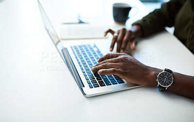 Buy stock photo Cropped shot of an unrecognisable businessman using a laptop at his desk in a modern office