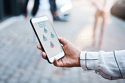 Buy stock photo Shot of an unrecognisable woman using a Covid-19 tracking app on her smartphone in the city