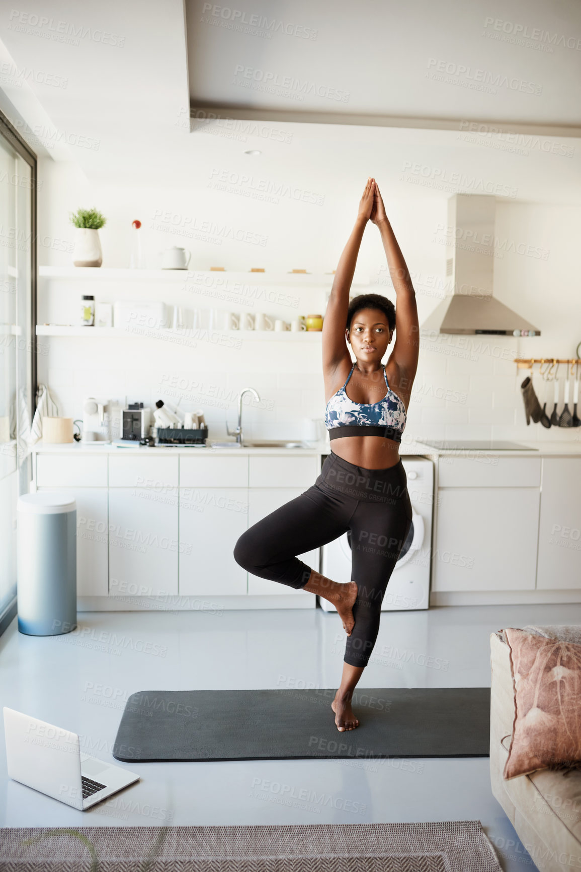 Buy stock photo Shot of a young woman using a laptop while exercising at home