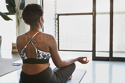 Buy stock photo Rearview shot of a young woman meditating at home
