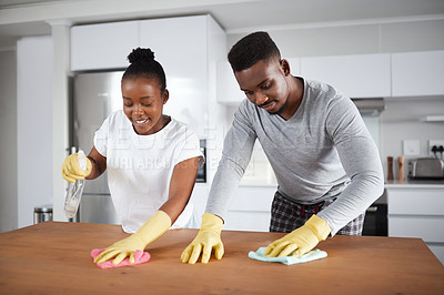 Buy stock photo Shot of a young couple cleaning the kitchen counter at home