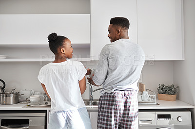 Buy stock photo Shot of a young couple washing the dishes together at home