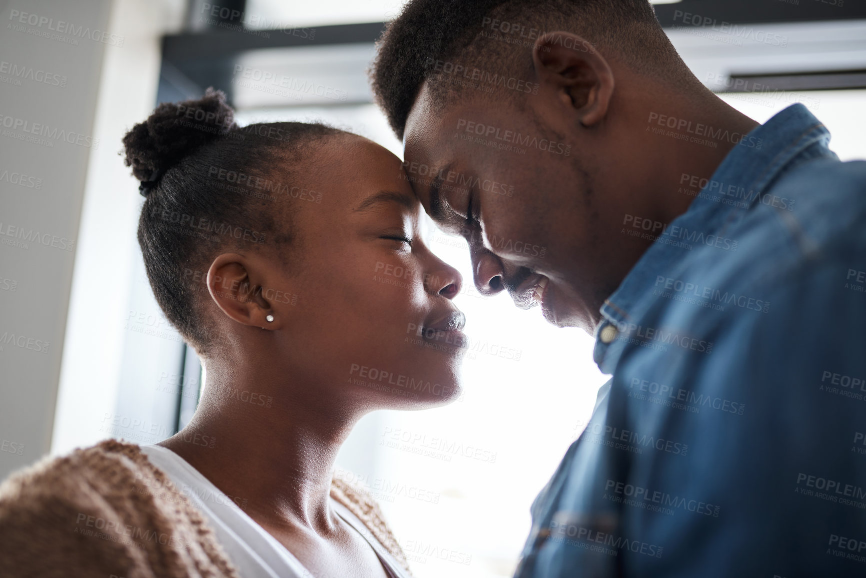 Buy stock photo Black couple, relax and forehead for love, care or relationship bonding together at home. African American man and woman touching heads in loving embrace for caring moment, trust or support indoors
