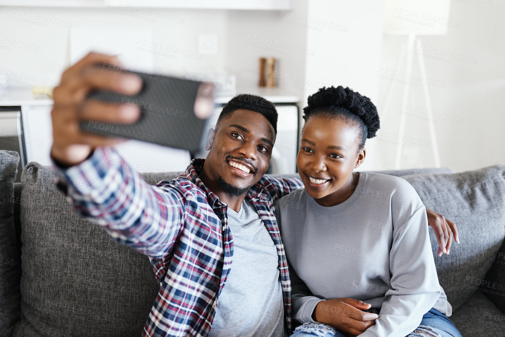 Buy stock photo Shot of a young couple taking selfies together at home