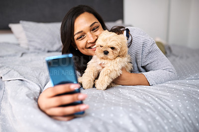 Buy stock photo Shot of a young woman taking selfies with her dog at home