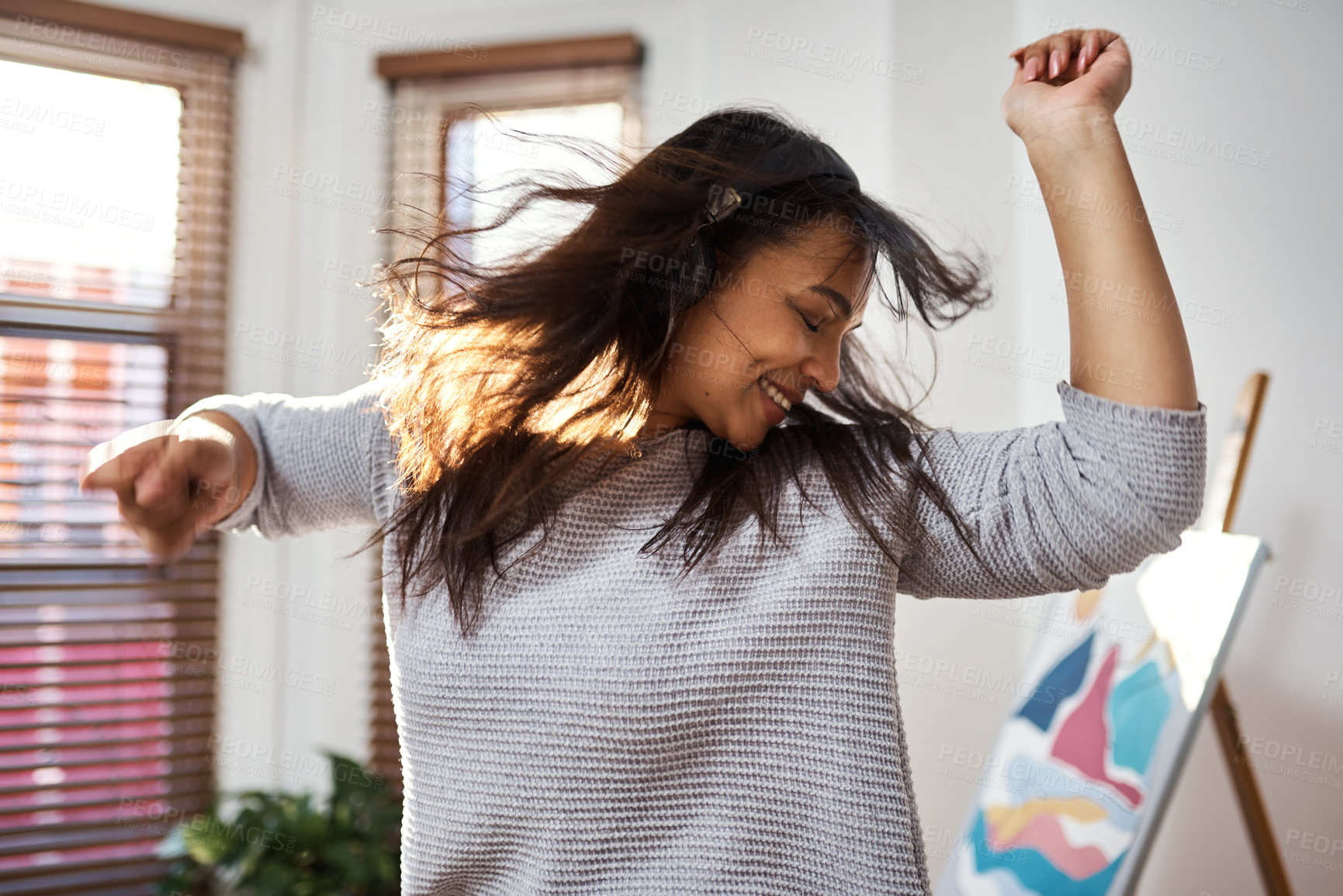 Buy stock photo Shot of a young woman dancing while listening to music at home