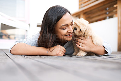 Buy stock photo Shot of a young woman relaxing with her dog on a wooden porch outdoors
