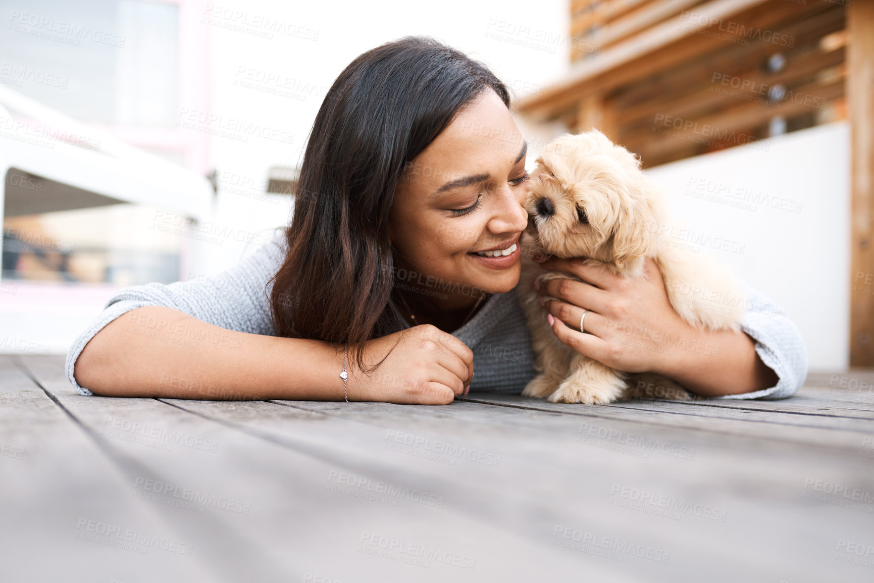 Buy stock photo Shot of a young woman relaxing with her dog on a wooden porch outdoors