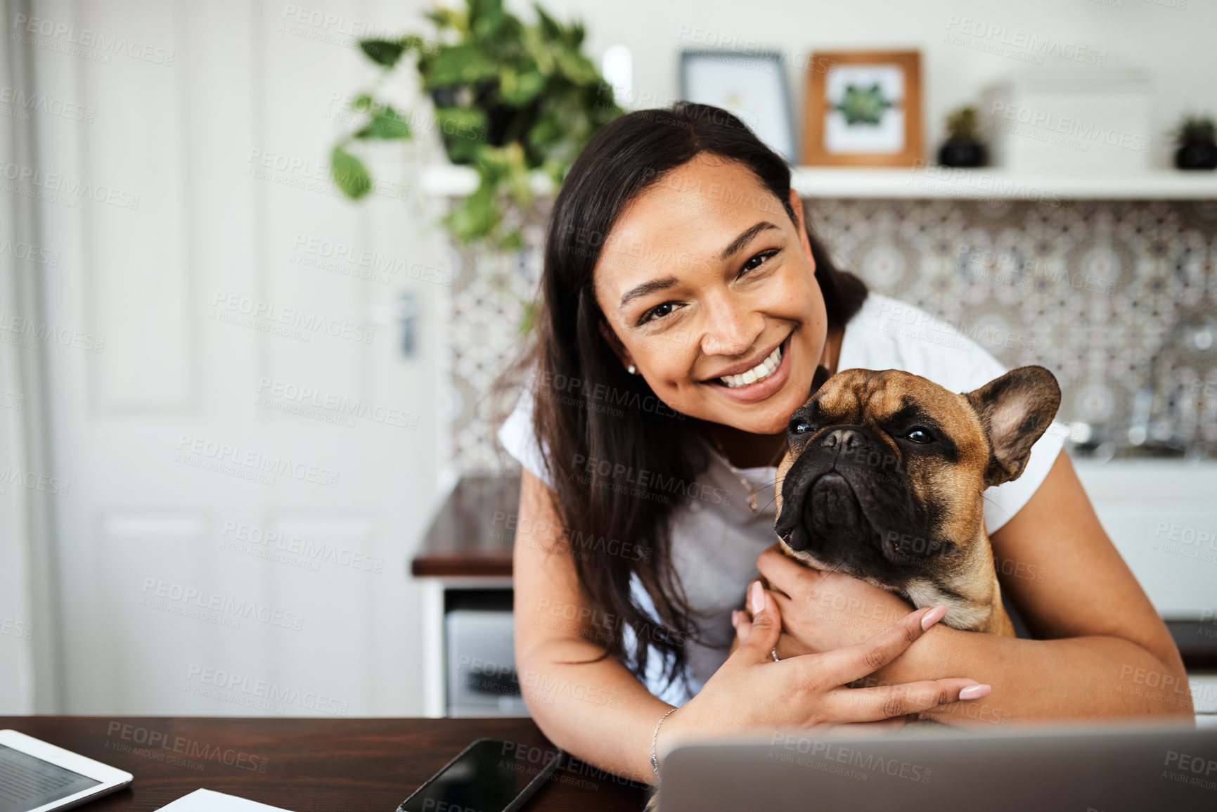 Buy stock photo Portrait of a young woman sitting with her pet dog on her lap while working from home