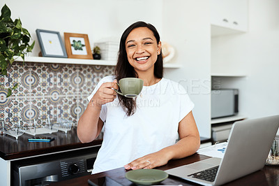 Buy stock photo Portrait of a young woman drinking coffee while working on a laptop at home
