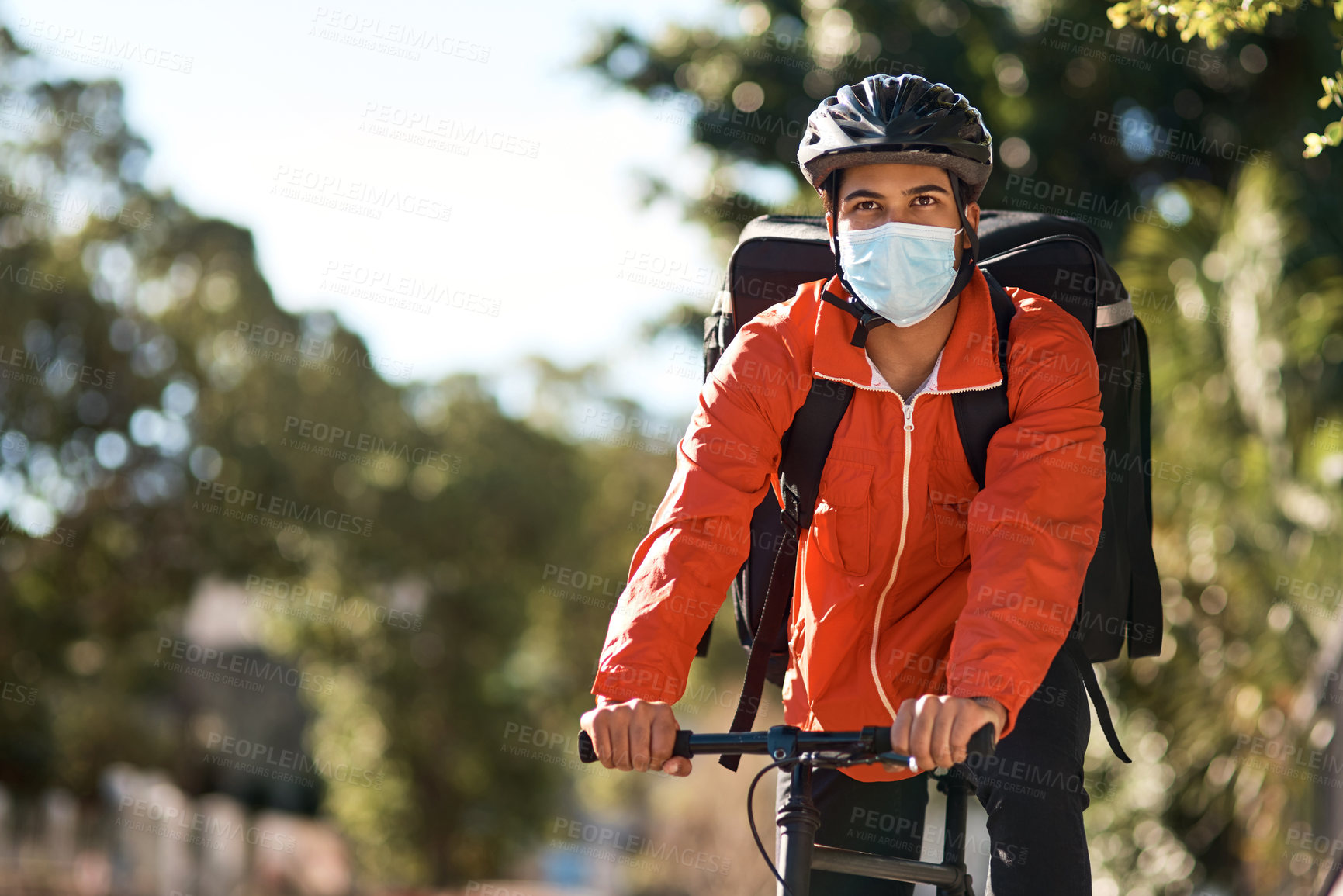 Buy stock photo Shot of a masked man out on his bicycle to do a delivery