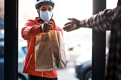 Buy stock photo Shot of a masked man delivering a food package