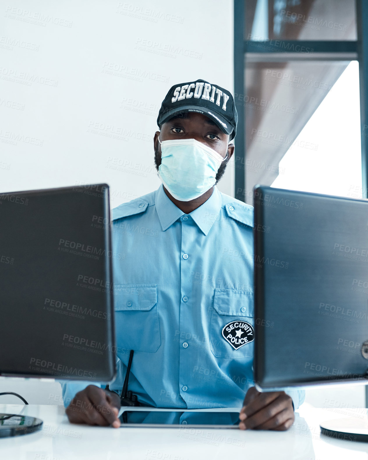 Buy stock photo Portrait of a confident masked young security guard on duty at the front desk of an office