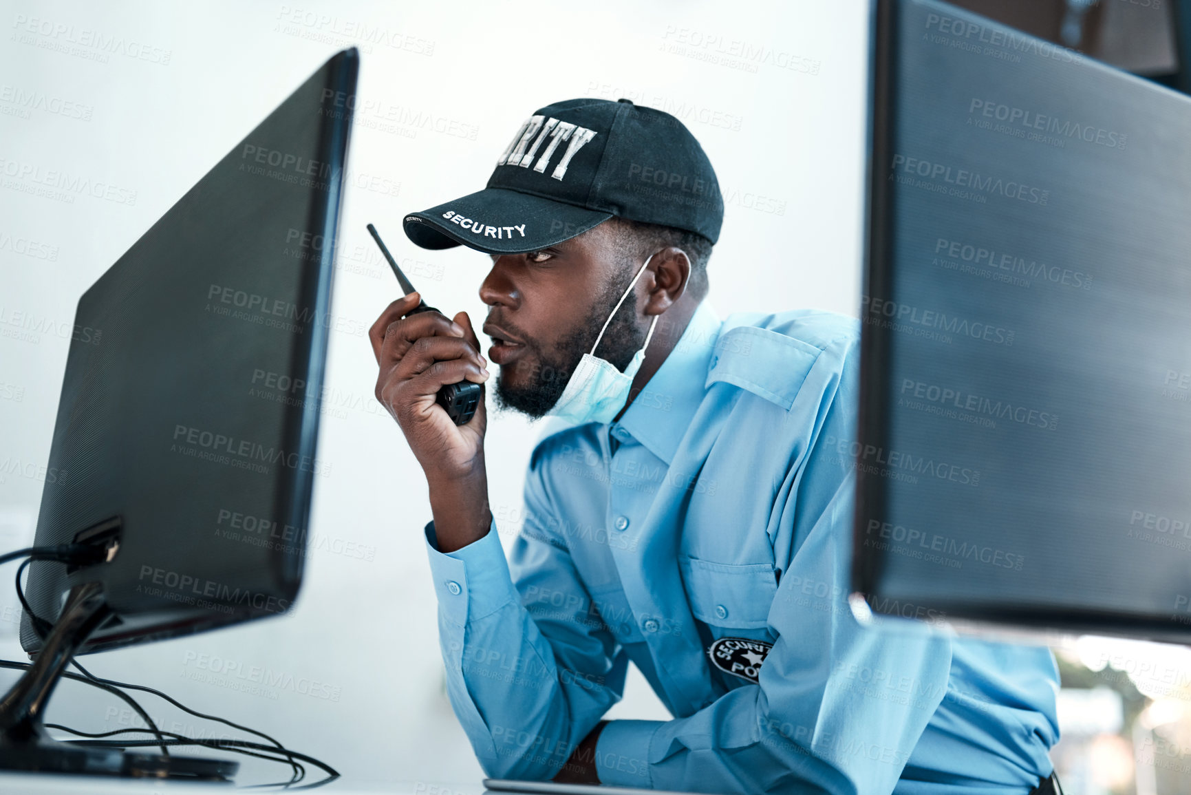Buy stock photo Shot of a young security guard using a two way radio while monitoring the cctv cameras