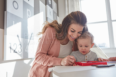 Buy stock photo Shot of a woman and her young son using crayons to draw at home