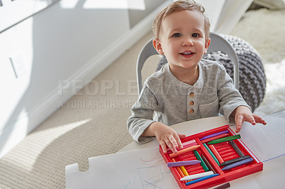Buy stock photo Cropped shot of a little boy playing with his crayons at home
