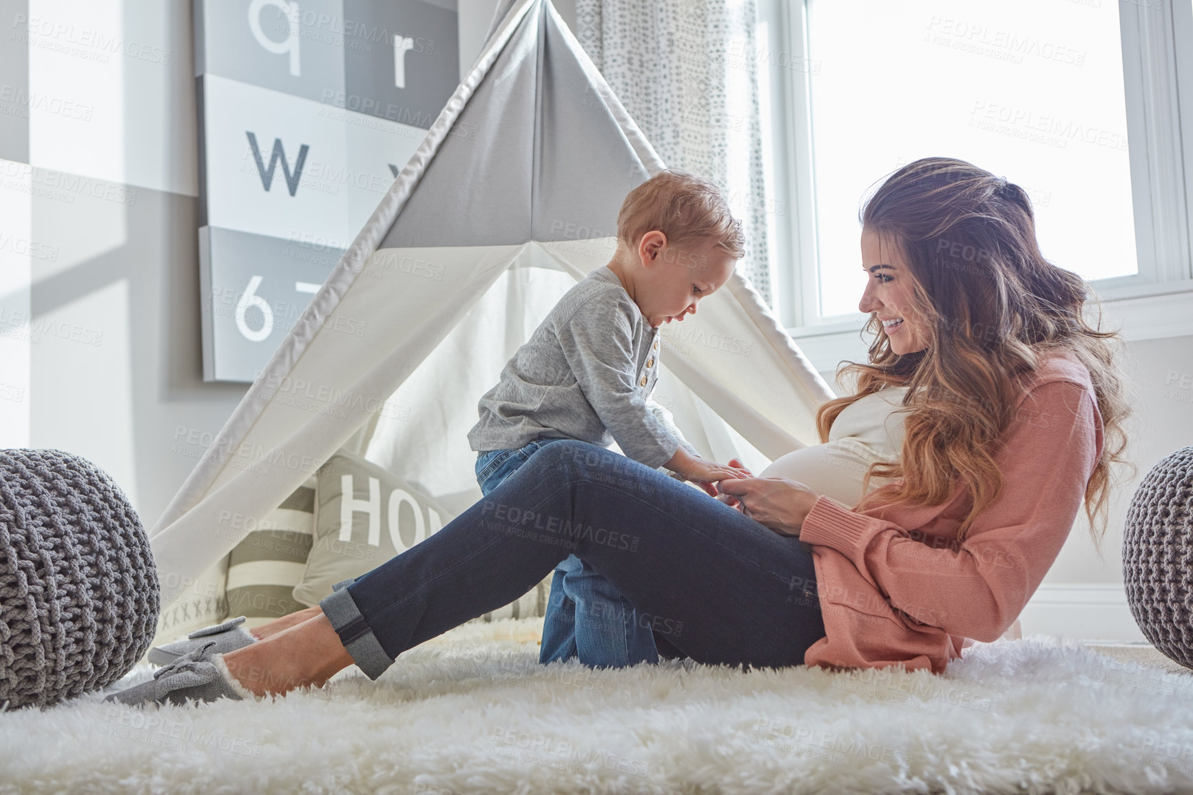 Buy stock photo Shot of a pregnant woman bonding with her toddler son at home