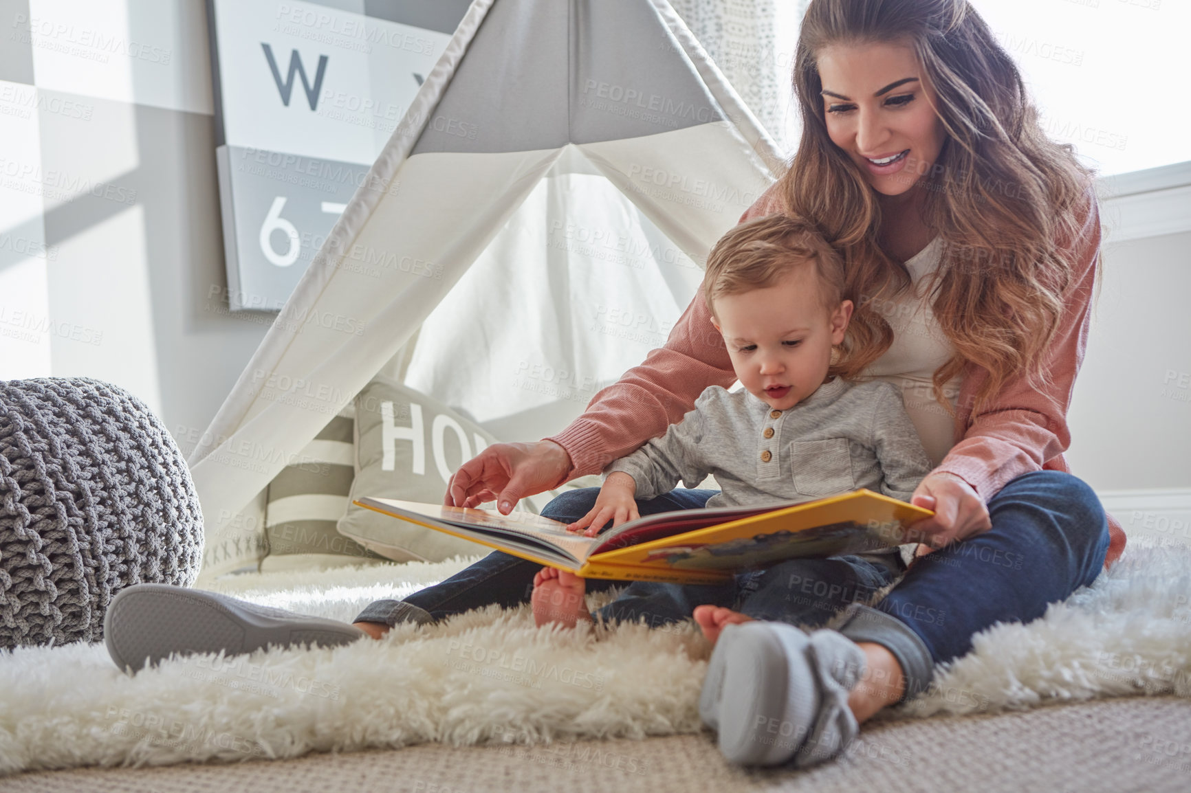 Buy stock photo Shot of a woman reading to her toddler son at home