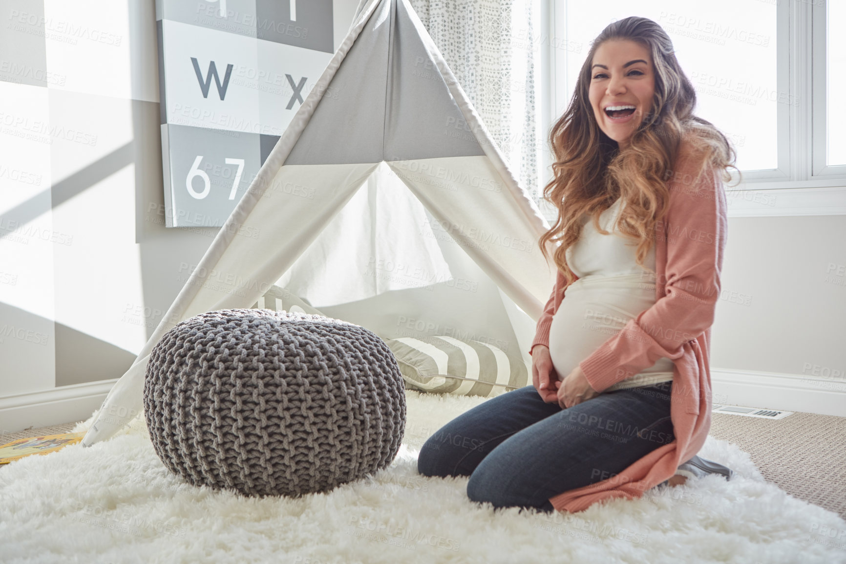Buy stock photo Shot of a pregnant woman looking happy while sitting at home