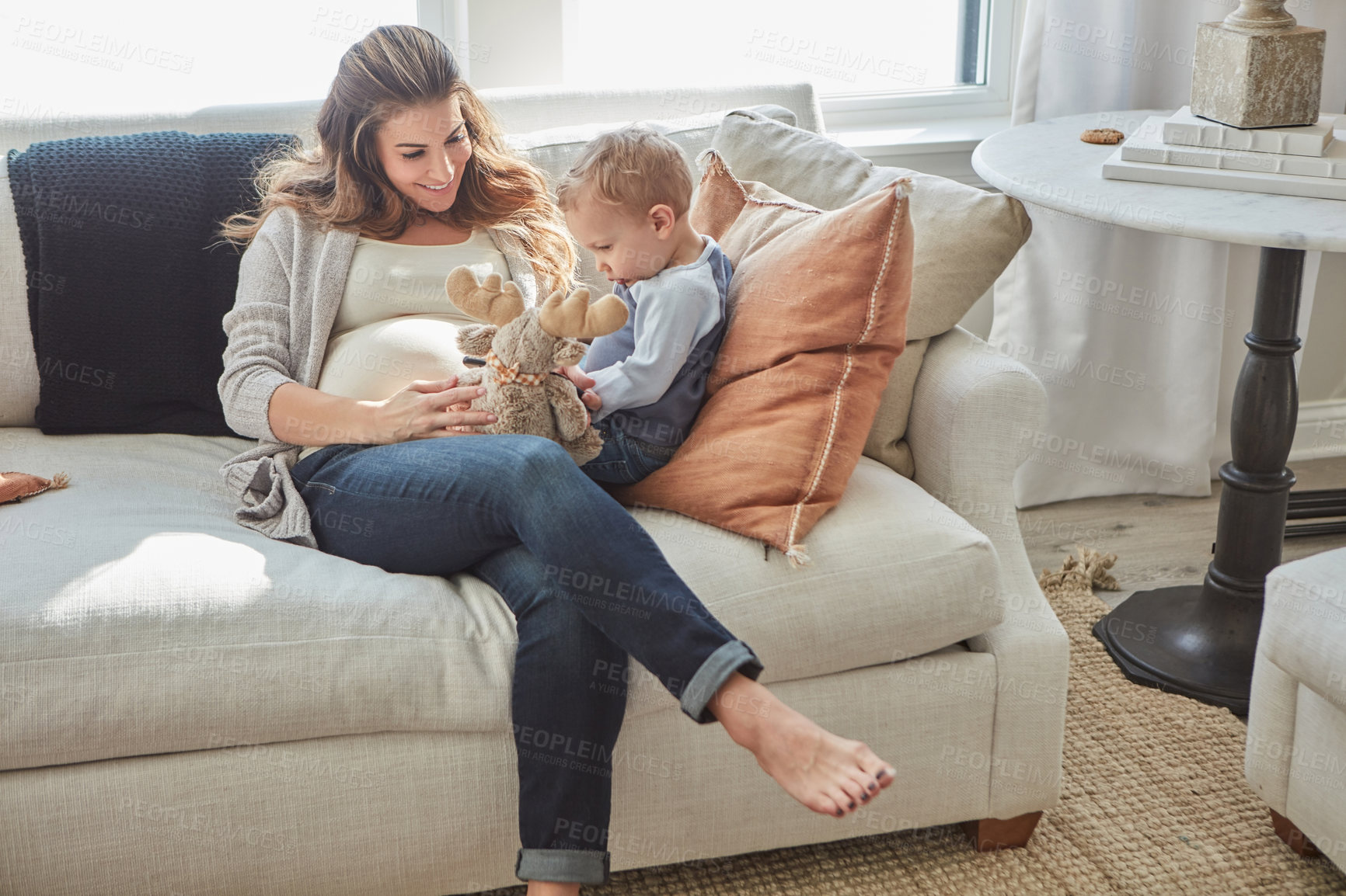 Buy stock photo Shot of a pregnant woman bonding with her toddler son at home