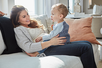 Buy stock photo Shot of a pregnant woman bonding with her toddler son at home
