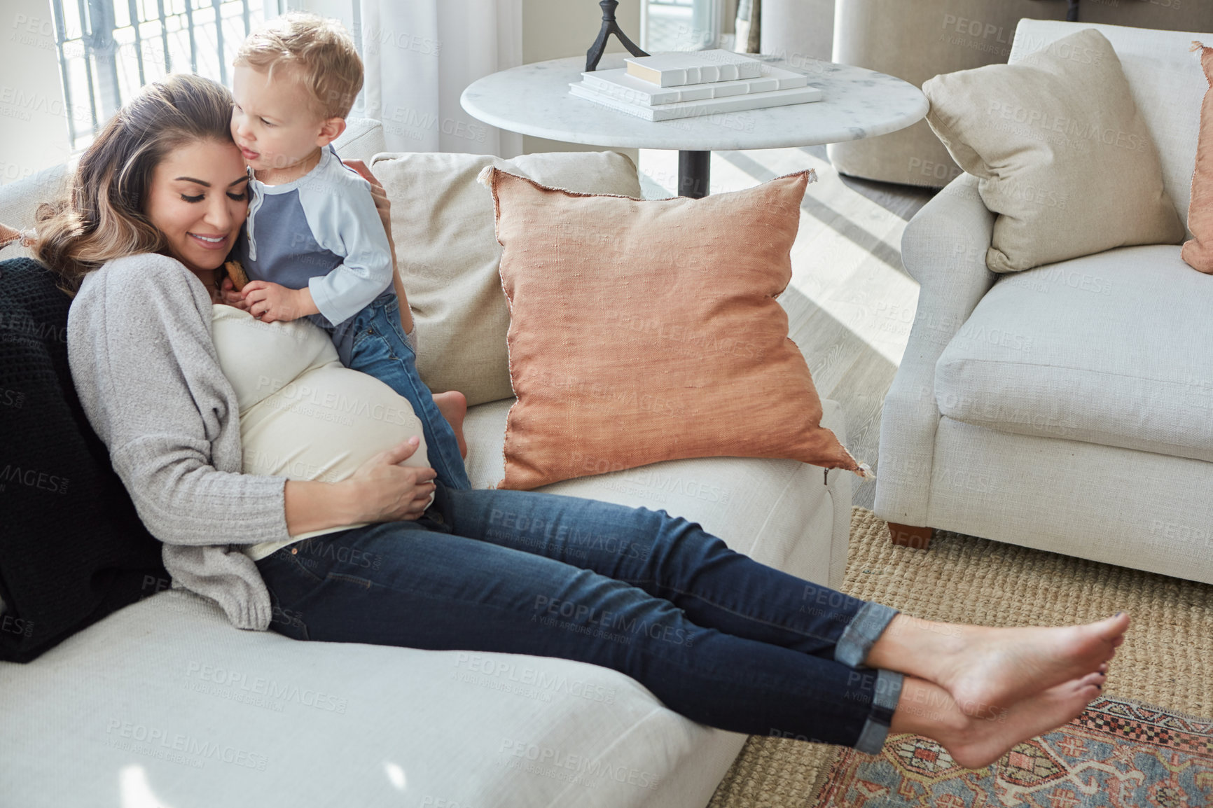 Buy stock photo Shot of a pregnant woman bonding with her toddler son at home