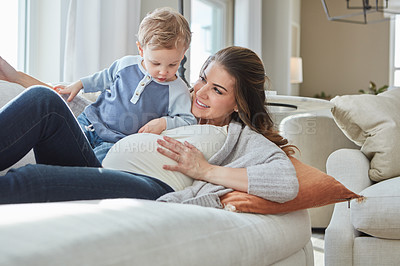 Buy stock photo Shot of a pregnant woman bonding with her toddler son at home