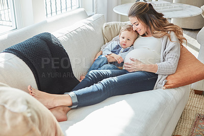 Buy stock photo Shot of a pregnant woman bonding with her toddler son at home