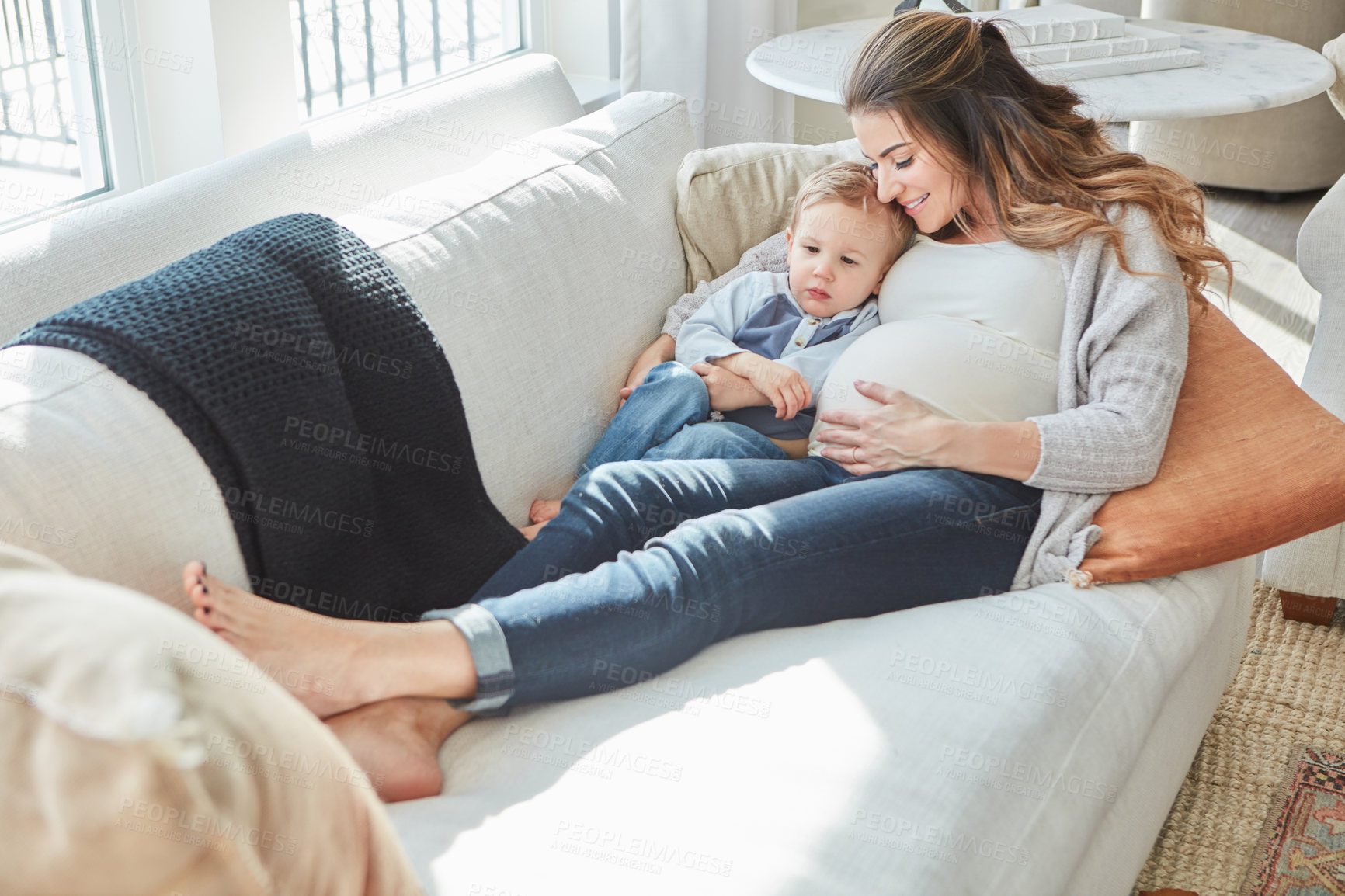 Buy stock photo Shot of a pregnant woman bonding with her toddler son at home