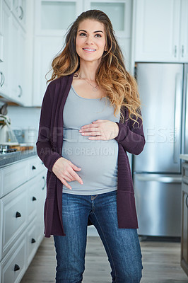 Buy stock photo Cropped shot of an attractive young pregnant woman standing in her kitchen at home