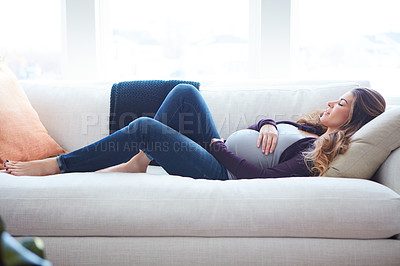 Buy stock photo Full length shot of an attractive young pregnant woman taking a nap on the sofa at home
